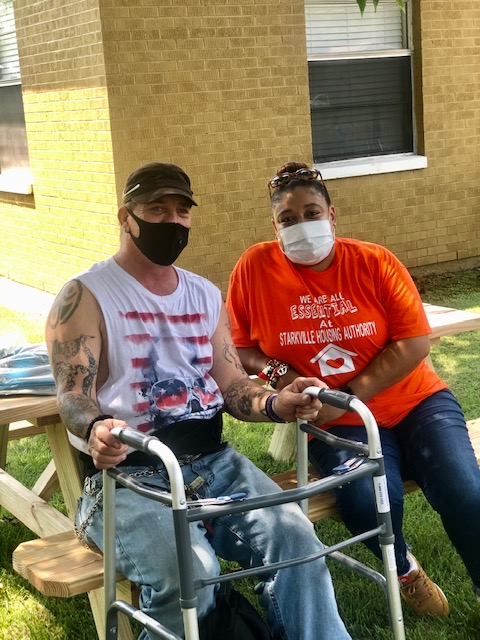 Two people sitting on a bench outside