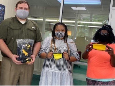 Group photo of people holding face masks