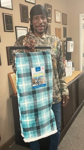 Man with a new blanket won from the raffle