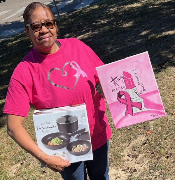 Woman holding her painting and a pan set